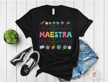 Black t-shirt with colorful ’MAESTRA’ text and flower designs printed on it.