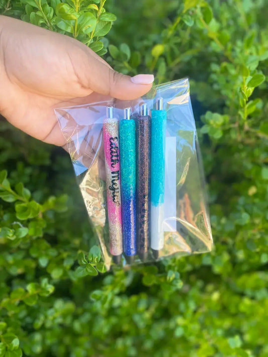 Hand holding a clear plastic bag containing colorful pens or markers.