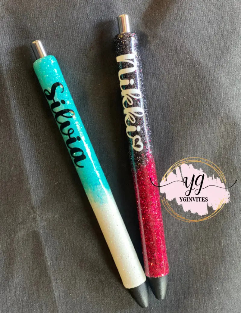 Two decorative glitter pens in turquoise/white and black/red/gold colors.