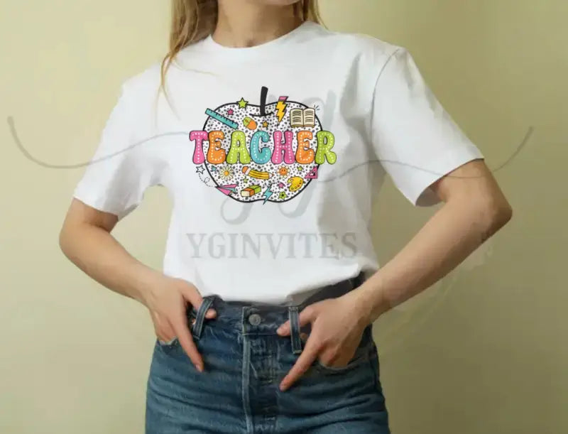 White t-shirt with colorful ’TEACHER’ text and school-themed doodles printed on the front.