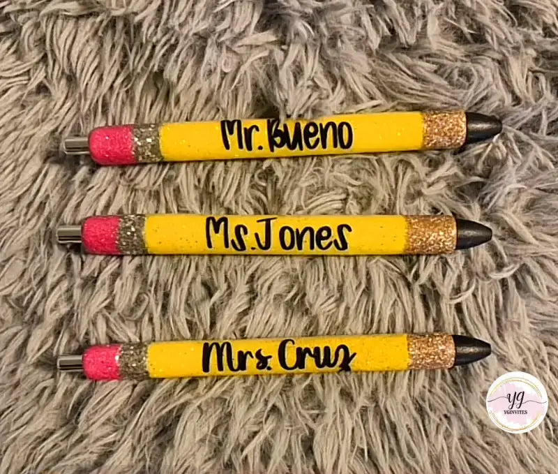 Three yellow pencils with pink erasers, gold glitter tips, and teacher names written in black.